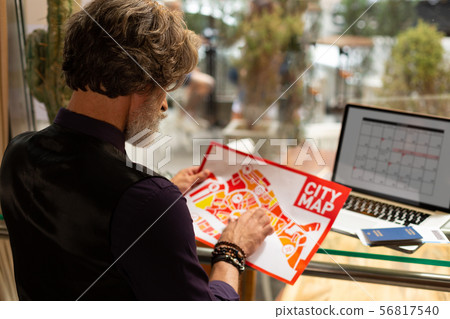 Man exploring the city map before going for a walk. 56817540