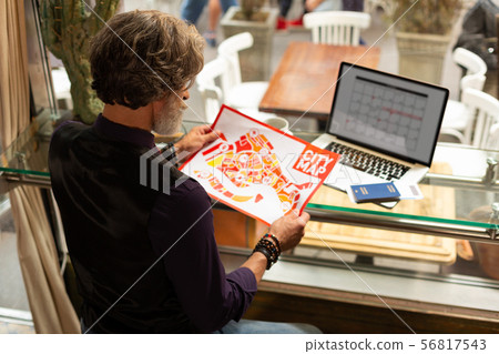 Tourist examining the city map in the cafe. 56817543
