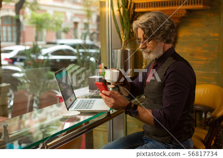 Serious man writing a message during his working day. 56817734