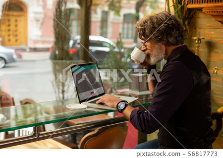 Handsome man enjoying his coffee and working. 56817773