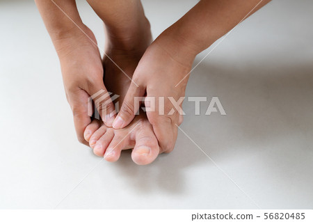 Woman massaging her painful foot and finger 56820485