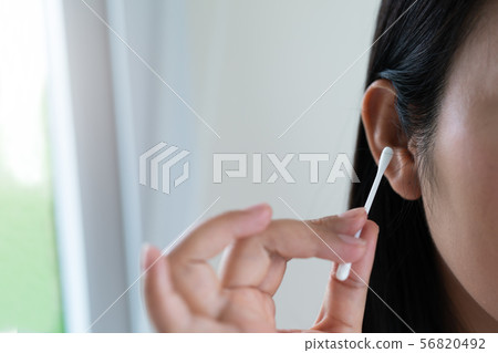 woman cleaning ear with cotton swab. Healthcare 56820492