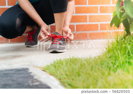 sport woman tying shoelace before running, outdoor 56820503
