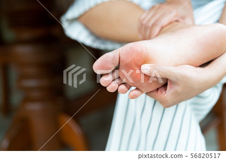 Woman massaging her painful barefoot, healthcare 56820517
