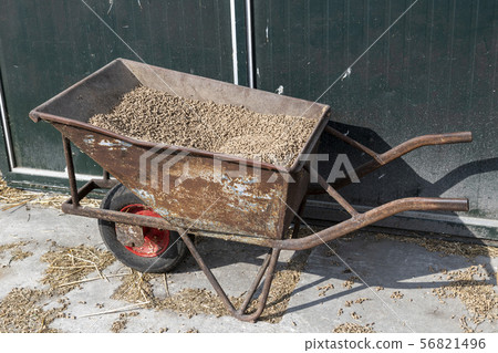 Old wheelbarrow with feed. 56821496