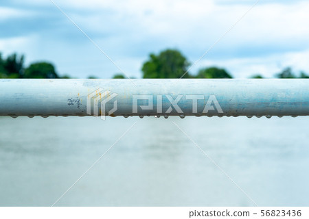 Selective focus on raindrops hanging under steel 56823436