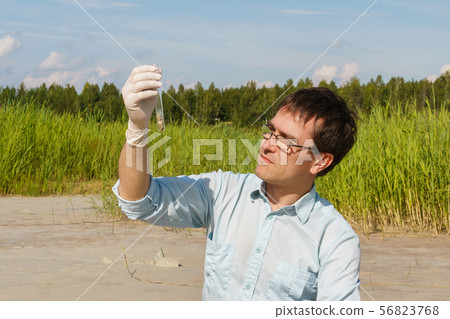 man ecologist or biologist examines soil sample in 56823768