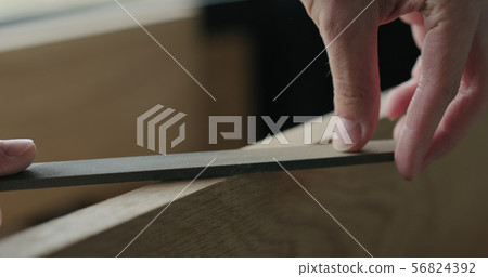 closeup man hand sandig oak board edge with file closeup man hand sandig oak board edge with file 56824392