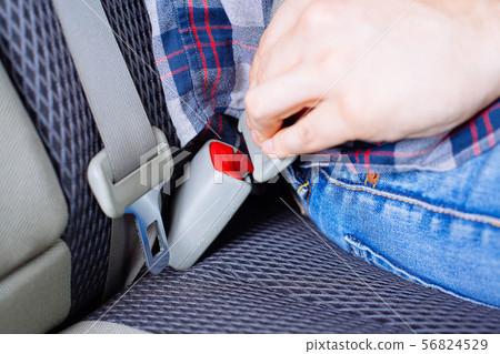 Men's hand fastens the seat belt of the car. Men's hand fastens the seat belt of the car. 56824529