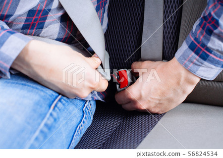 Men's hand fastens the seat belt of the car. Men's hand fastens the seat belt of the car. 56824534