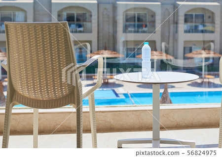 Plastic bottle of water and empty chair on balcony Plastic bottle of water and empty chair on balcony 56824975