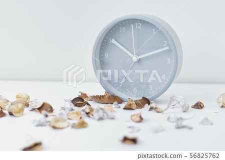 Classic alarm clock and petals on a white table 56825762