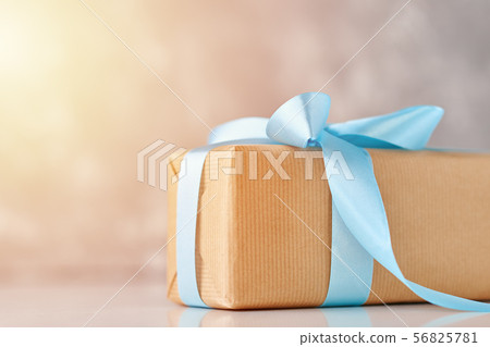 close up gift box in craft paper with blue ribbon close up gift box in craft paper with blue ribbon 56825781