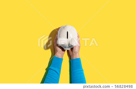 Person holding a piggy bank Person holding a piggy bank 56828498