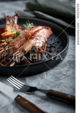 Grilled king prawns, with tomato sauce on a gray background, low key. Series concrete background 56829208