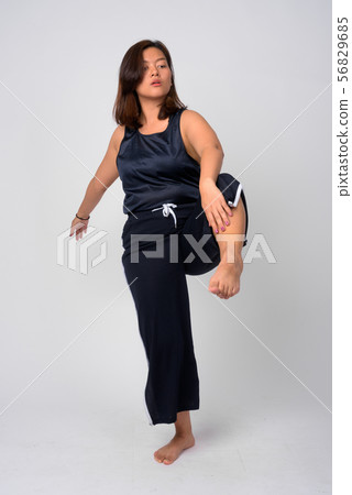 Young beautiful Asian woman dancing and standing on one leg Young beautiful Asian woman dancing and standing on one leg 56829685