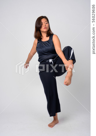 Young beautiful Asian woman dancing and standing on one leg Young beautiful Asian woman dancing and standing on one leg 56829686