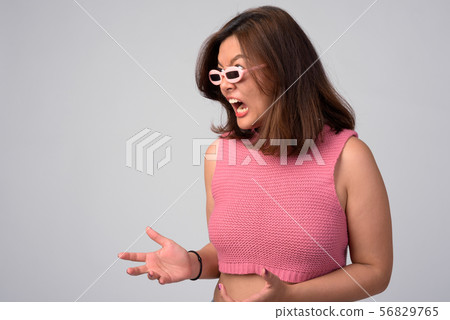 Profile view of young angry Asian woman with novelty glasses Profile view of young angry Asian woman with novelty glasses 56829765
