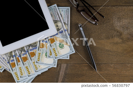Tablet pc with a pen, glasses and dollar bills on Tablet pc with a pen, glasses and dollar bills on 56830797