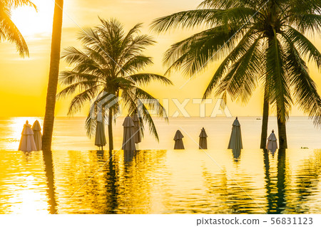 Beautiful outdoor tropical nature landscape of swimming pool in hotel resort with coconut palm tree umbrella and chair nearly sea ocean beach 56831123