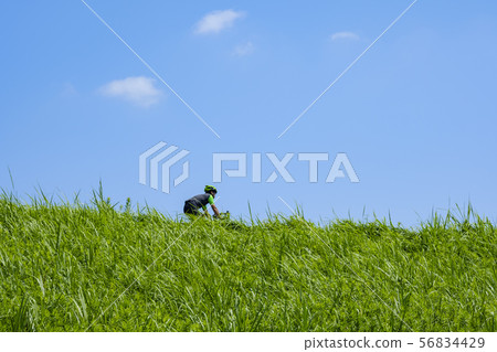 Cyclist with bank and blue sky Cyclist with bank and blue sky 56834429