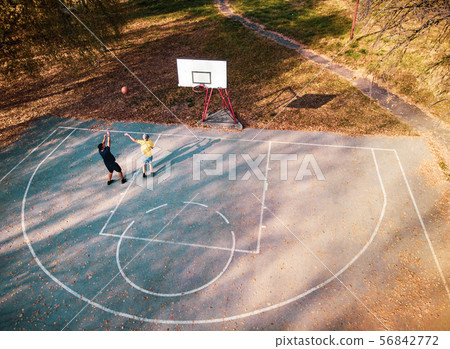 Father and son playing basketball in the park Father and son playing basketball in the park 56842772