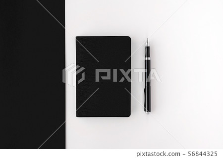 Top view of closed black notepad with black fountain pen on black and white background. Mockup for Top view of closed black notepad with black fountain pen on black and white background. Mockup for 56844325