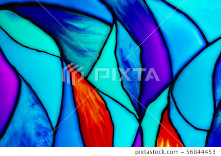Small fragment of a beautiful colorful stained glass background including orange, turquoise, blue 56844453