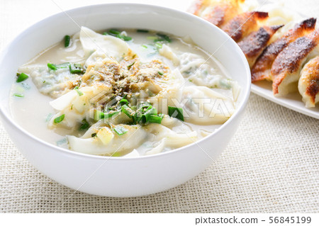 Wonton soup with spring onion served in a white 56845199
