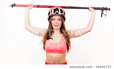 Woman wearing ski suit and helmet holding poles Woman wearing ski suit and helmet holding poles 56845337