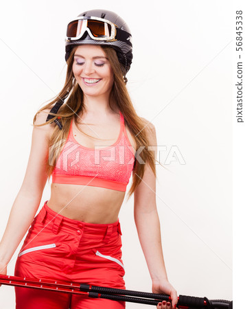 Woman wearing ski suit and helmet holding poles Woman wearing ski suit and helmet holding poles 56845338