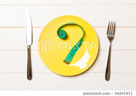 Fork and plate with measuring tape on color 56845911