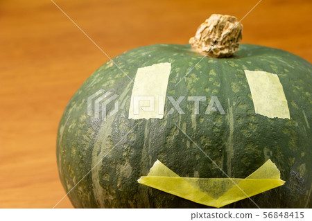 用萬聖節傑克o燈籠樣式修稿帶裝飾的南瓜。 用萬聖節傑克o燈籠樣式修稿帶裝飾的南瓜。 56848415