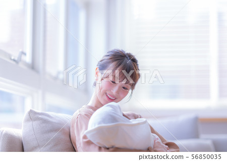 Lifestyle woman daytime woman natural light baby parenting indoor infant young childcare childcare 56850035