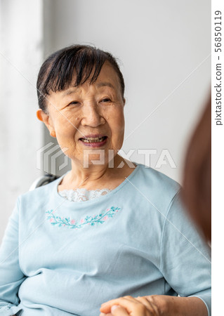 Caregiver nestling and senior woman in wheelchair Caregiver nestling and senior woman in wheelchair 56850119