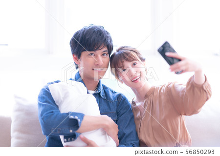 Lifestyle couple newlywed male female daytime man woman natural light baby parenting indoor infant young childcare 56850293