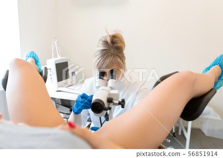 A gynecologist examines a patient on a A gynecologist examines a patient on a 56851914