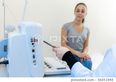 The doctor explains to the patient girl the 56851948
