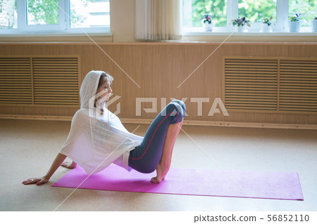Young woman ballerina stands on her tip toes on the yoga mat - dance studio Young woman ballerina stands on her tip toes on the yoga mat - dance studio 56852110