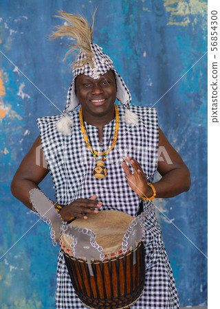African artist in traditional clothes playing djembe drum African artist in traditional clothes playing djembe drum 56854300