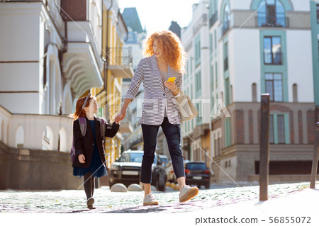 Joyful young woman walking with her daughter 56855072