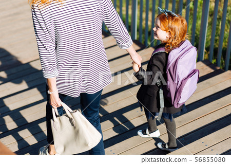 Positive delighted red haired girl going downstairs 56855080