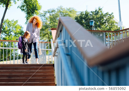 Cheerful red haired female talking to her kid 56855092