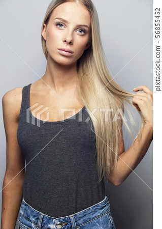 Beautiful young girl holding her blonde hair Beautiful young girl holding her blonde hair 56855452