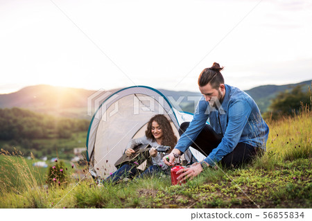 Young tourist couple travellers with tent shelter sitting in nature, resting. 56855834