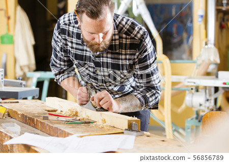Carpenter work with plane on wood plank in workshop 56856789