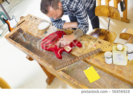 Craftsman working at workshop with a guitar 56856928