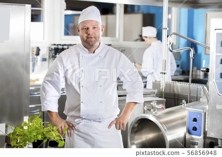 Portrait of confident and smiling chef making food in large kitchen 56856948