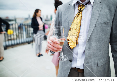 A group of joyful businesspeople having a party outdoors on roof terrace in city. A group of joyful businesspeople having a party outdoors on roof terrace in city. 56857044