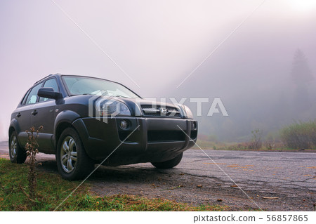 suv on the road side in fog suv on the road side in fog 56857865